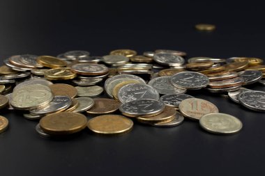 Siyah bir arkaplanda metal madeni paraların dağılması.