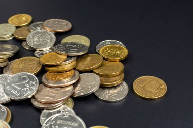 Siyah bir arkaplanda metal madeni paraların dağılması.