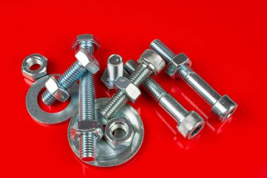 Kırmızı arka plandaki yapıları bağlamak için cıvatalar ve fındıklar