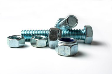 beyaz arkaplanda hafif metalden yapılmış cıvata ve fındık grubu