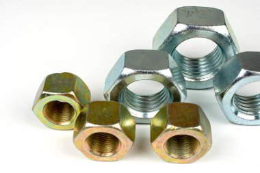 Beyaz arka planda birkaç büyük metal fındık.