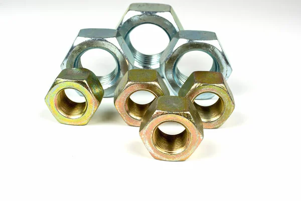 Beyaz arka planda birkaç büyük metal fındık.