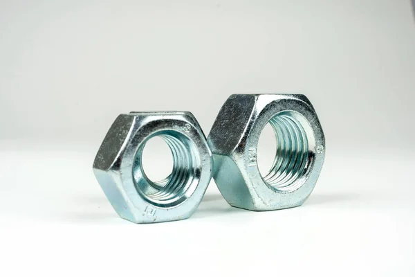 beyaz arkaplanda hafif metalden yapılmış cıvata ve fındık grubu