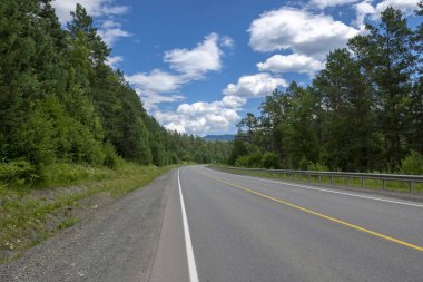 Otoyol ve dağ zirveleri bulutlu mavi gökyüzünün arka planında