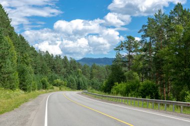 Otoyol ve dağ zirveleri bulutlu mavi gökyüzünün arka planında