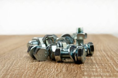 Tahta bir yüzeye birkaç somun ve cıvata.