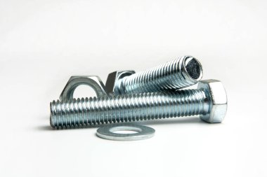 Beyaz arkaplandaki bir grupta birkaç büyük somun ve cıvata