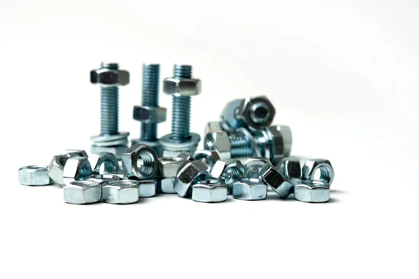 Beyaz arkaplandaki bir grupta birkaç büyük somun ve cıvata