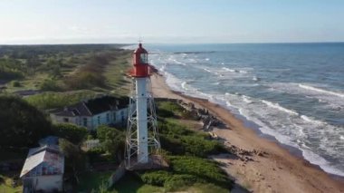 Pape deniz fenerinden uçan bir hava görüntüsü. Eski kırmızı deniz feneri. Mavi deniz arka planı