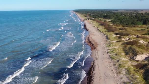 Pape deniz fenerine doğru uçan bir hava görüntüsü. Eski kırmızı deniz feneri. Mavi deniz arka planı — Stok video