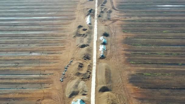 Letecký záběr letící po silnici nad rašeliništěm. Těžba rašeliny. Hromady rašeliny. — Stock video