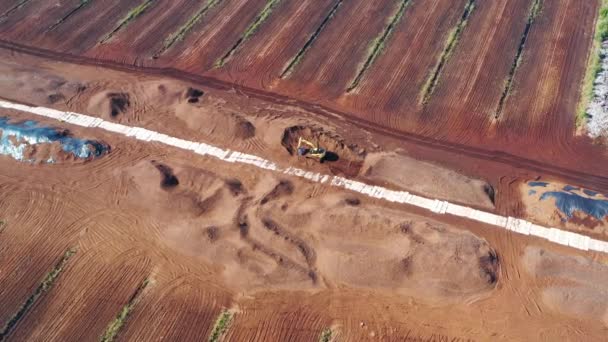 Aerial orbitando tiro giratório em torno de pilhas de turfa e escavadeira. Campo de colheita de turfa. Extracção de turfa — Vídeo de Stock