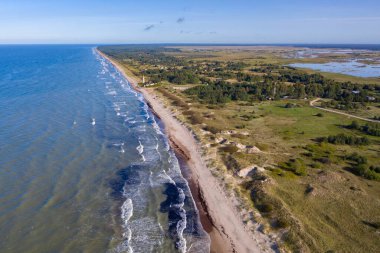 Papanın Baltık Denizi ile Pape Gölü arasındaki hava görüntüsü. Mavi gökyüzü. Pape deniz feneri
