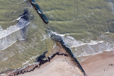 Denizde eski taştan dalgaların dalgalanma rıhtımına karşı kırılma görüntüsü.