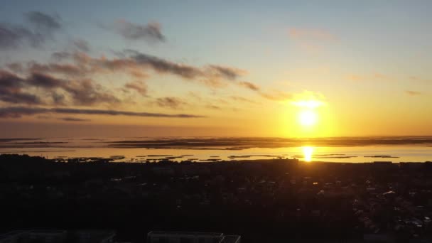 Foto aérea de hermoso amanecer naranja sobre Liepaja. Reflejo del sol en el lago Liepaja — Vídeos de Stock