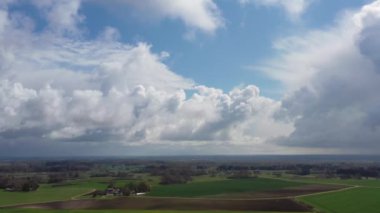 Beyaz bulutlara ve yeşil yemyeşil tarlalara doğru uçan hava görüntüleri