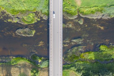 Köprüden geçen arabanın havadan aşağı görüntüsü. Nehir köprünün altından akıyor