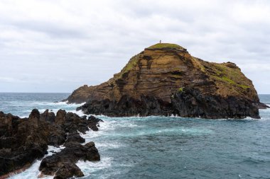 Waves crashing against black rocks in Porto Moniz in Madeira, Portugal