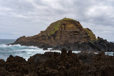 Waves crashing against black rocks in Porto Moniz in Madeira, Portugal