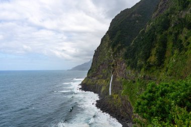Veu da Noiva waterfall flowing into the Atlantic Ocean in Madeira, Portugal
