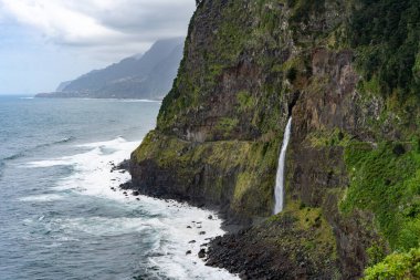 Veu da Noiva waterfall flowing into the Atlantic Ocean in Madeira, Portugal
