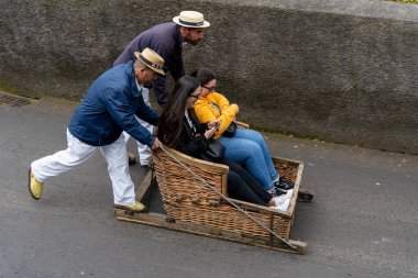 Funchal, Madeira, Portekiz - 03.27.2025: Funchal, Madeira, Portekiz 'de Monte kızakla seyahat eden turistler