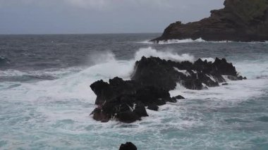 Portekiz, Madeira 'daki Porto Moniz' de siyah kayalara vuran dalgaların yavaş hareketi