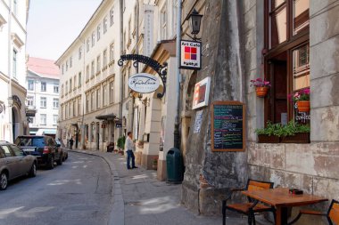 Cracow, Mayıs 2012. 2012 'de Cracow' un eski bir kasabasında restoran ve kafe ile kavisli bir cadde ve menüyü okuyan bir turist..