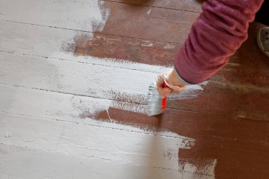 Evde tamirat yapılıyor. Döşeme tahtalarını boyamak.