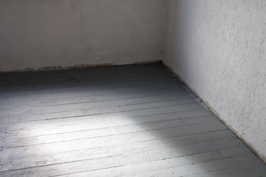 Tamirat sırasında stüdyonun boş beyaz odası. Döşeme tahtaları birinci kat boyalıdır..