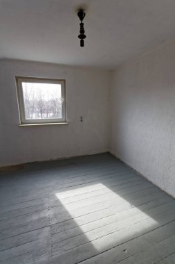 Tamirat sırasında stüdyonun boş beyaz odası. Döşeme tahtaları birinci kat boyalıdır..