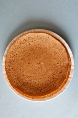 Mavi masanın üstünde büyük bir tabağa istiflenmiş gözlemeler..