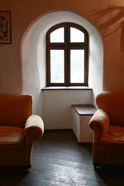 Arched window of a historic building interior with quite modern furniture
