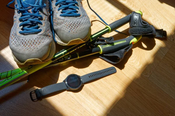 İskandinav yürüyüş seti - ayakkabılar, direkler ve spor saati.