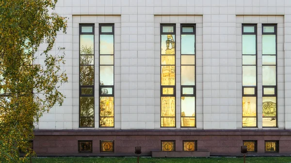 Window reflections of old university building in autumn Moscow