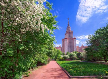 Moskova 'da baharda mavi bulutlu gökyüzünün altında beyaz çiçek açan elma ağaçları ile ünlü üniversitenin güneşli kampüsü
