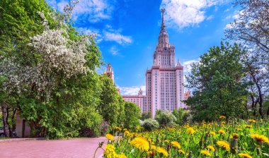 Moskova 'da baharda mavi bulutlu gökyüzünün altında beyaz çiçek açan elma ağaçları ile ünlü üniversitenin güneşli kampüsü