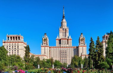 Moskova 'daki eski üniversitenin güneşli kampüsü yazın mavi gökyüzünün altında güzel çiçekler ve yemyeşil ağaçlarla