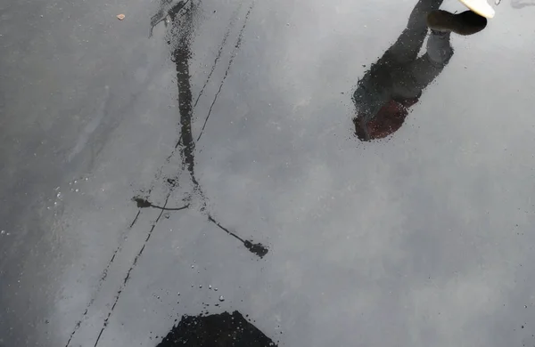 湿淋淋的沥青路面上莫斯科街道和女孩的水倒影 — 图库照片
