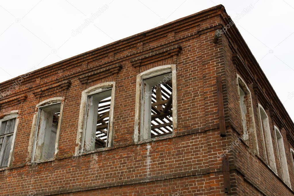abandoned red brick building with three windows