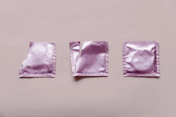 Preservativo e dois pacotes em branco no fundo rosa — Fotografia de Stock