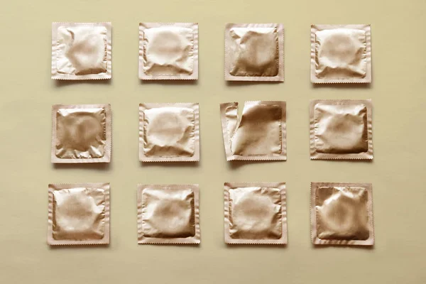 Padrão de muitos preservativos e pacote vazio no fundo bege — Fotografia de Stock