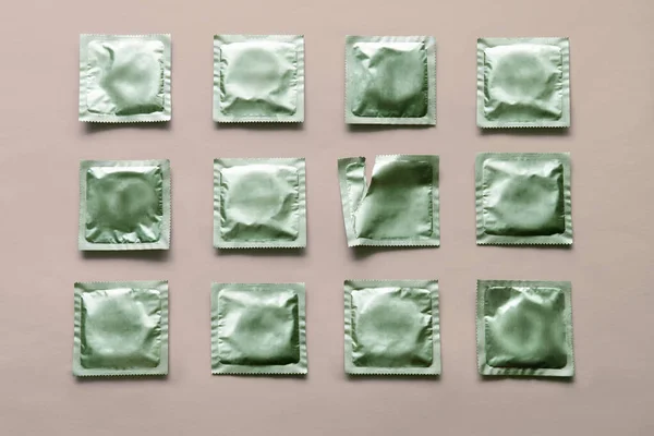 Padrão de muitos preservativos verdes e pacote vazio no fundo rosa — Fotografia de Stock