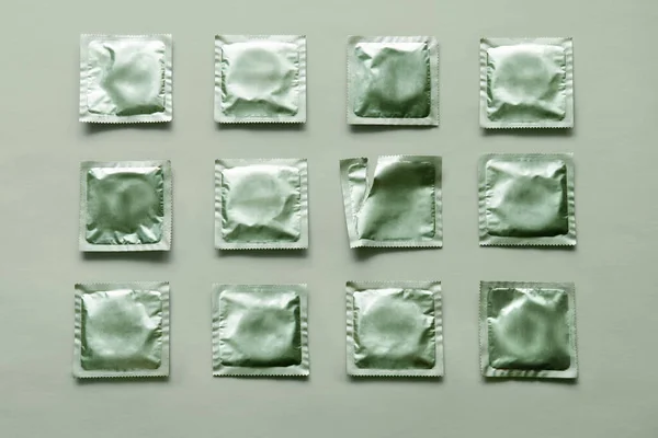Padrão de muitos preservativos verdes e pacote vazio no fundo verde — Fotografia de Stock