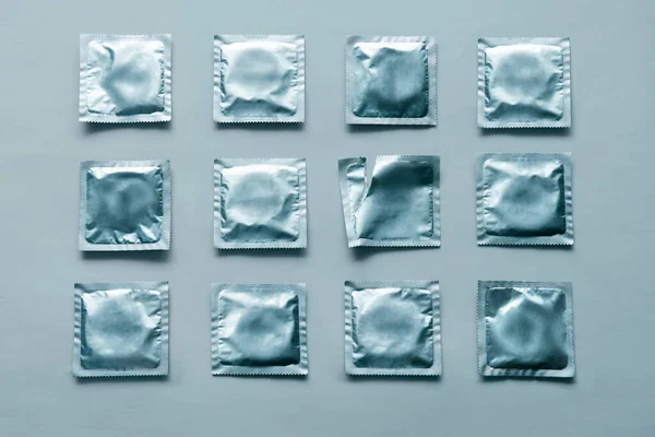 Padrão de muitos preservativos azuis e pacote vazio no fundo azul. — Fotografia de Stock