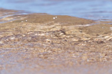 Sahildeki güzel deniz kumlarında devam eden dalgalar.