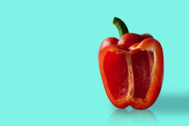 Yarım dolmalık biber mavi arka planda duruyor..