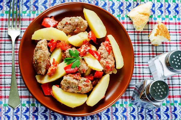 meat cutlets baked with potatoes, tomatoes and red pepper