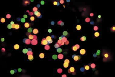 Mutlu Noel tatili için dekorasyon. Mutlu yıllar. Parıldayan Mavi ve Turuncu Yumuşak-Odaklı Işıklar yanıp sönüyor. Odaklanma özellikleri. Lens Bokeh. İşaret fişeği. Karanlık Arkaplan. Kapat.