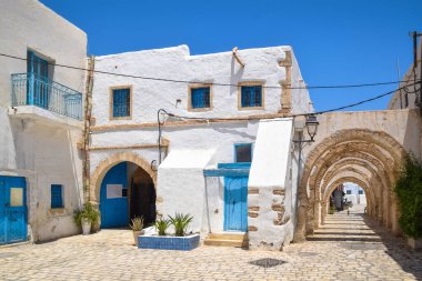Djerba Adası 'nın başkenti Houmt Souk, Tunus' ta mavi kapılı geleneksel bir beyaz ev..